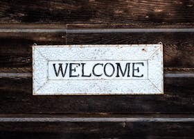 A rustic vintage-style 'Welcome' sign on a wooden wall creating a warm and inviting atmosphere.